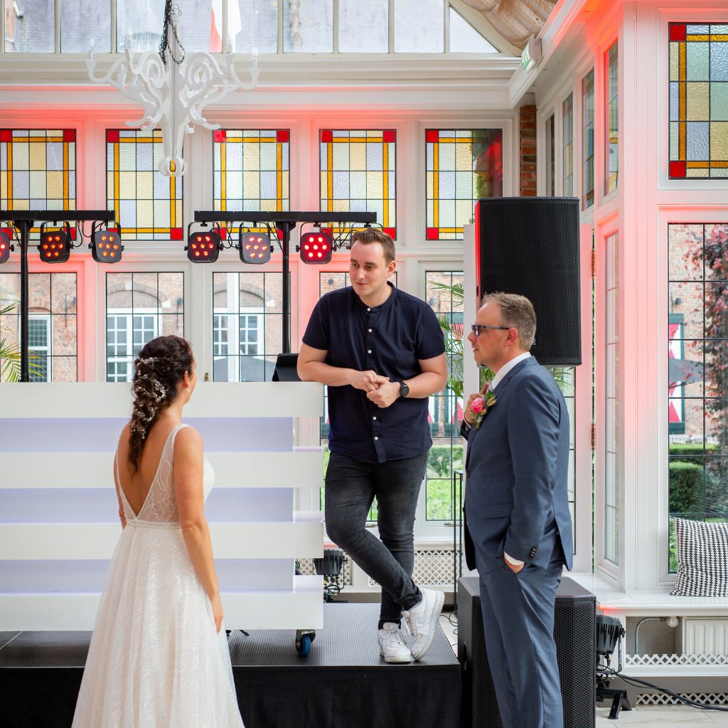 TimoV in overleg met een bruidspaar bij zijn DJ-booth